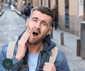un visage crispé vu de profil, les dents serrées avec des signes de tension autour des mâchoires.