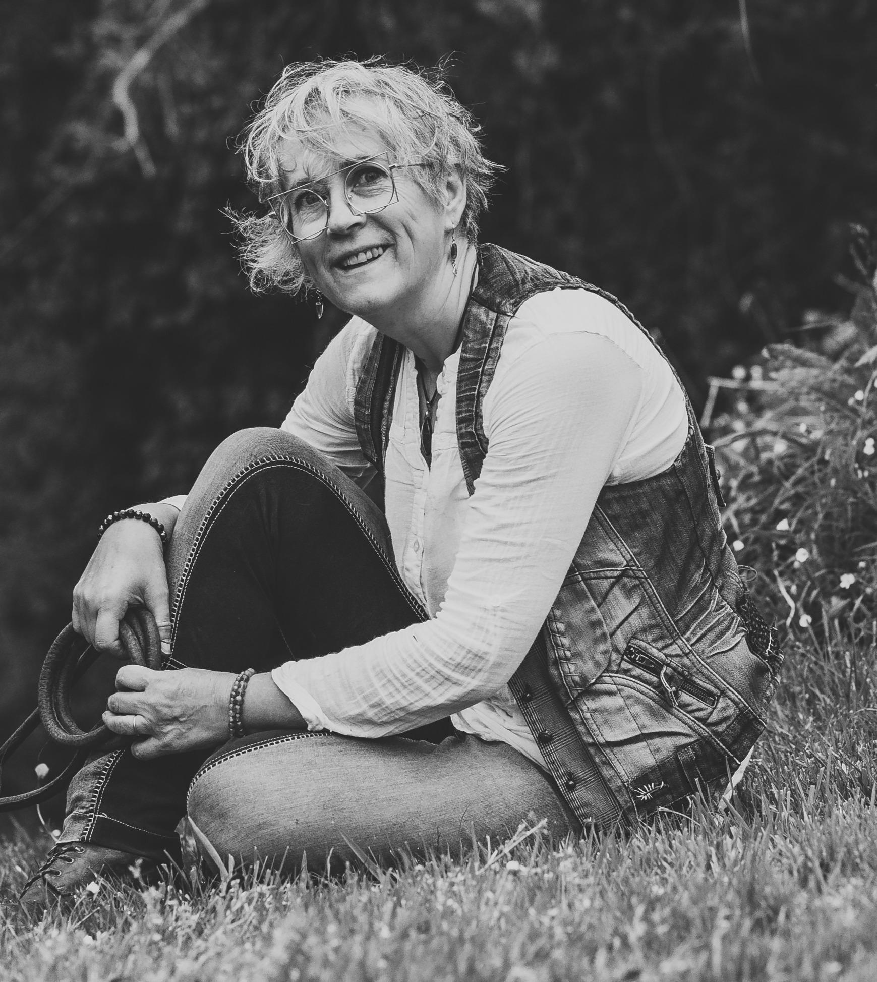 Laurence Carlo Guilloux, souriante et assise dans l’herbe,